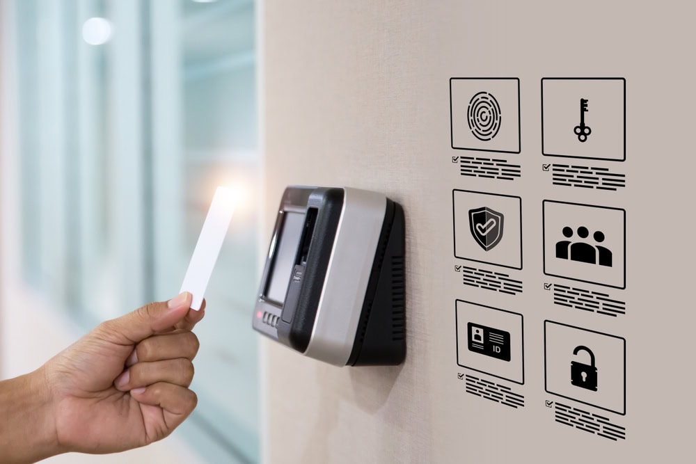 A person holds a key card to an electronic access control device on a wall. Nearby, security icons—including fingerprint and shield—highlight advanced protection, ideal for Locksmith Services Delaware County, PA.